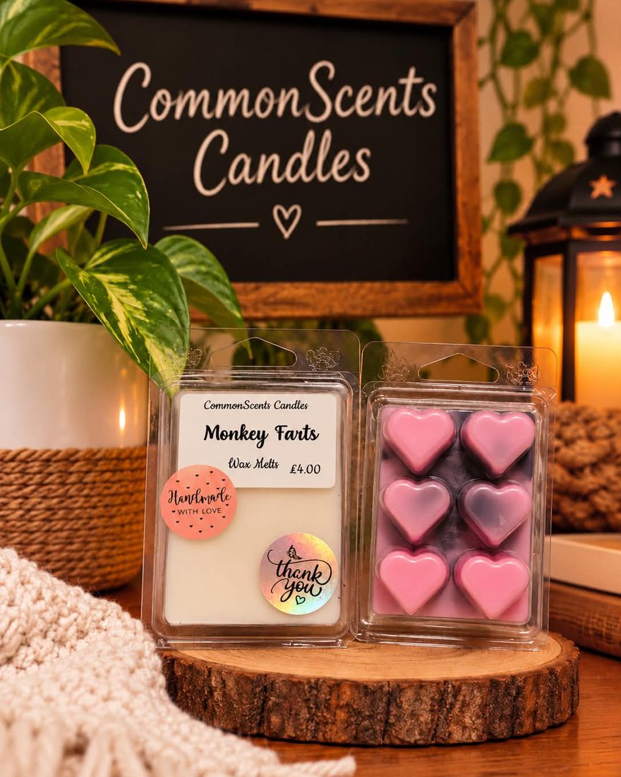 Two packs of Monkey Farts heart-shaped wax melts on a wooden slice, in front of a chalkboard sign reading CommonScents Candles